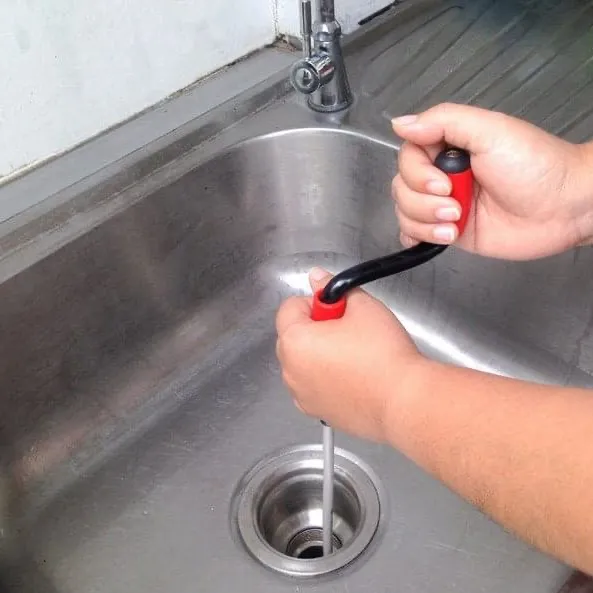using a drain auger plumber's snake to unblock a sink