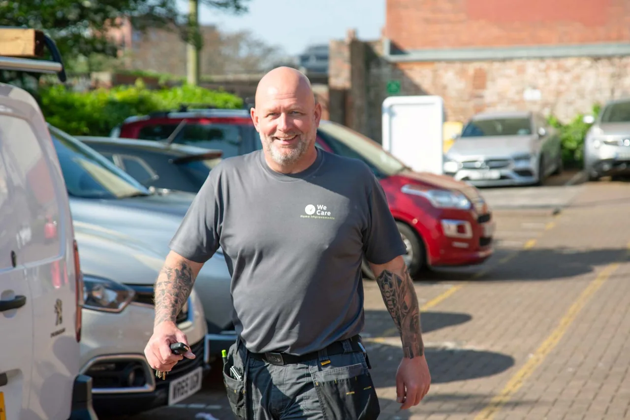 A We Care Home Improvements handyperson with his tools, beside the team van